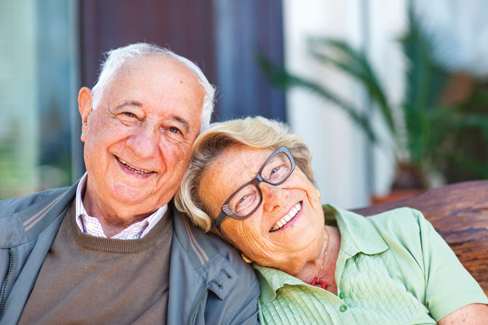 senior couple sitting and smiling outside