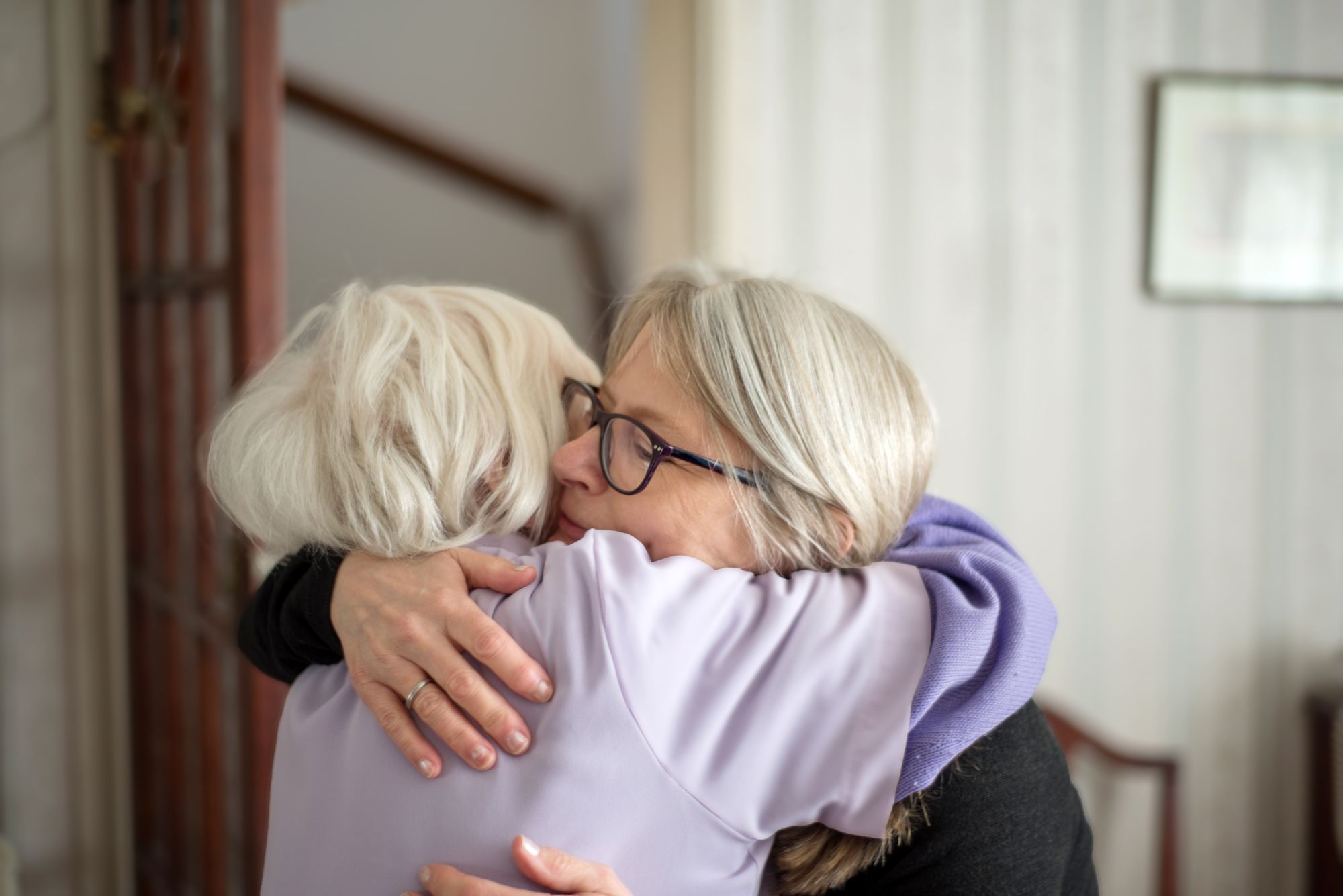 senior woman hugging other senior woman